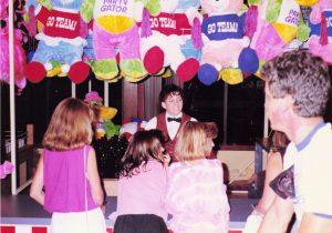 Female customers and attendant underneath plush prizes at Ring Toss game at Barrel of Fun #13, Commander Ragtime's