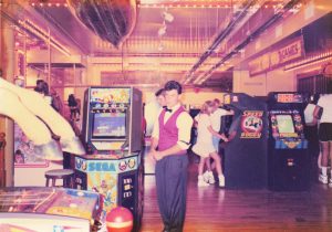 A red-vested employee checks the arcade floor amid games like Quartet, Ring King, and Speed Buggy at Barrel of Fun #13, Commander Ragtime's