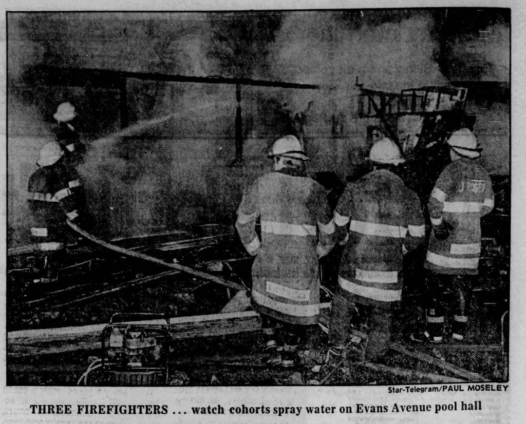 Black & white newspaper photo of firefighters with caption "Three firefighters...watch cohorts spray water on Evans Avenue pool hall.