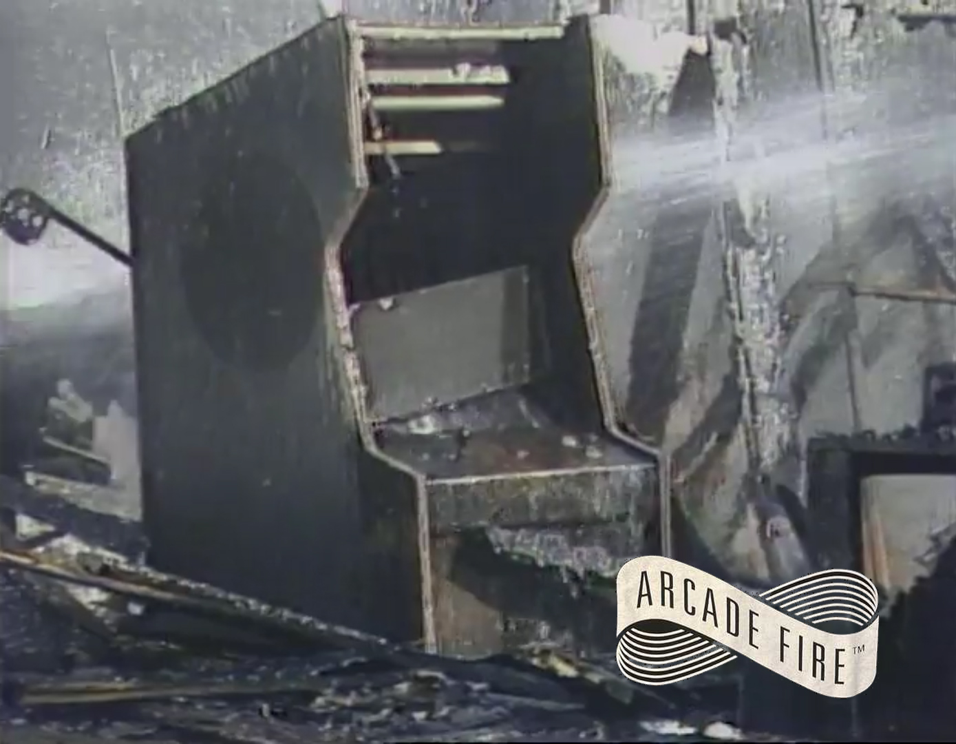 Burned husk of an arcade cabinet being sprayed by water