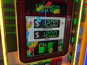 Arcade game screen reading WINNER, with $12.00 Target Sale and $12.00 Bonus, a fuel gauge graphic, and ticket images